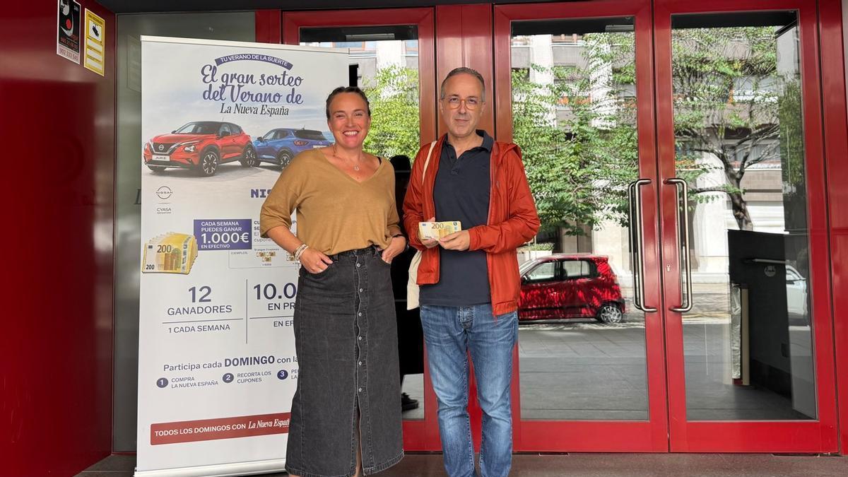 Eva González, de LA NUEVA ESPAÑA, entregando los 1.000 euros a Rubén Martínez Fernández.