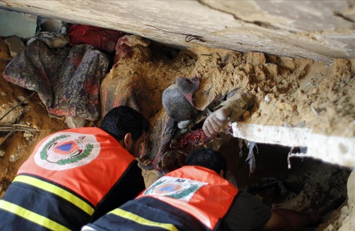 Los equipos de rescate palestinos encuentran el cuerpo de un hombre entre los escombros de su casa después de un ataque israelí en Rafah.