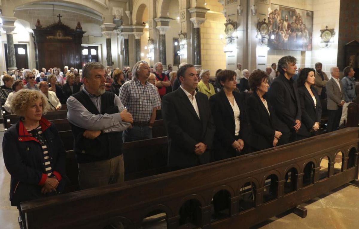 A la izquierda, la familia de Emilio  García, ayer, en su funeral. Junto a estas líneas, la entrada a la peluquería Escotet, en la calle  Argüelles, ahora cerrada. | F R. 