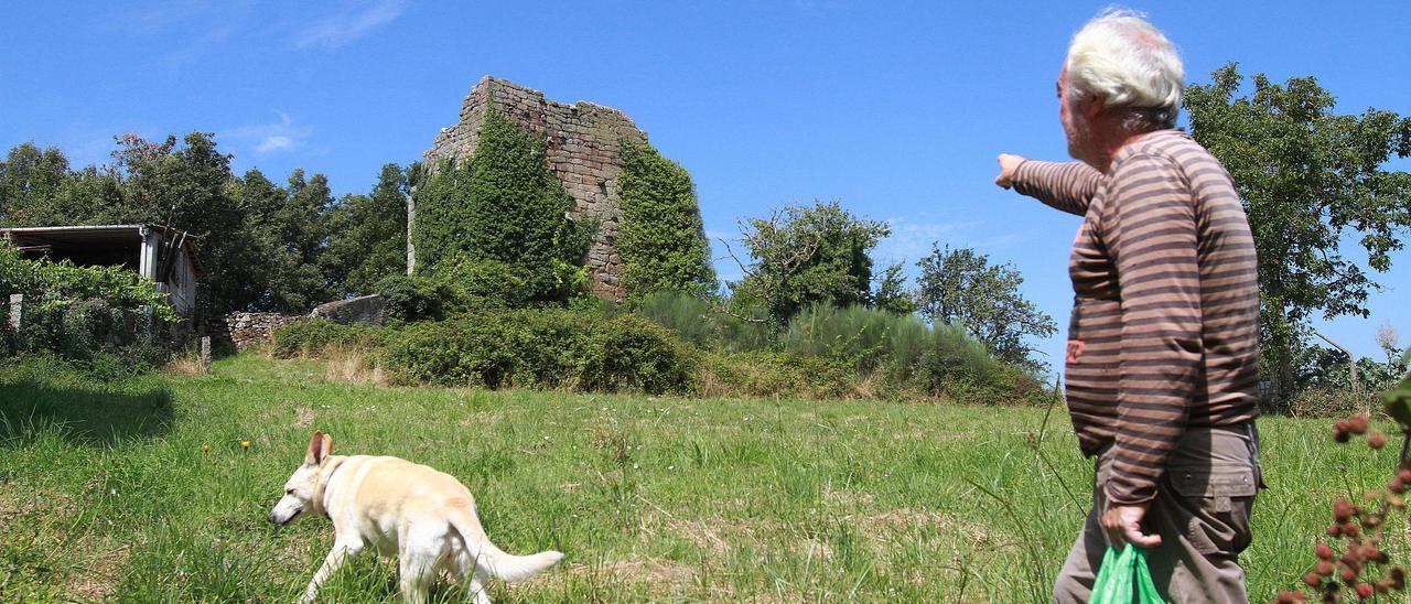 Un vecino señala la torre en ruinas de Torán, en Taboadela, uno de los monumentos en abandono. // IÑAKI OSORIO