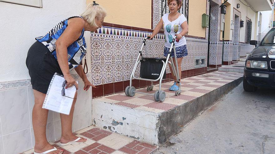 Adela Martín, en la puerta de su casa junto a Carmela Fernández, presidenta de la asociación de vecinos de Campanillas.