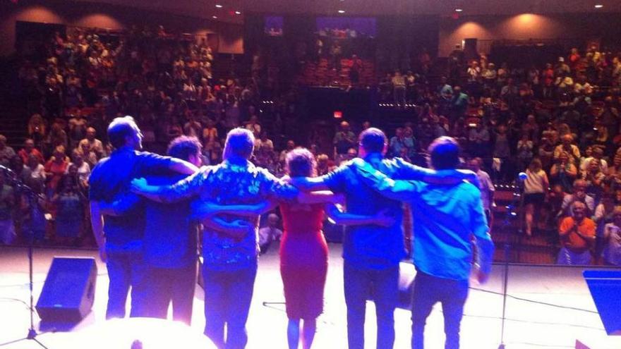 Músicos avilesinos saludan al público de San Agustín de la Florida tras un concierto en la ciudad norteamericana.