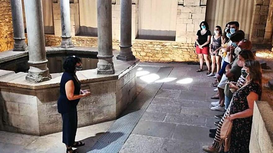 Una guia dona explicacions als participants en una visita a Girona.