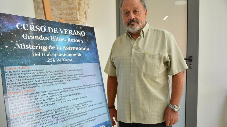 Carlos Gonzalez junto al cartel del curso de verano &#039;Grandes hitos, retos y misterios de la astronomía&#039;