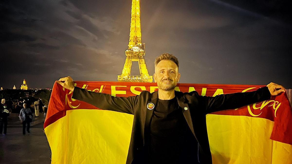 Paco Nogueras, con la bandera española a los pies de la Torre Eiffel, en París, sede del mundial de peluquería