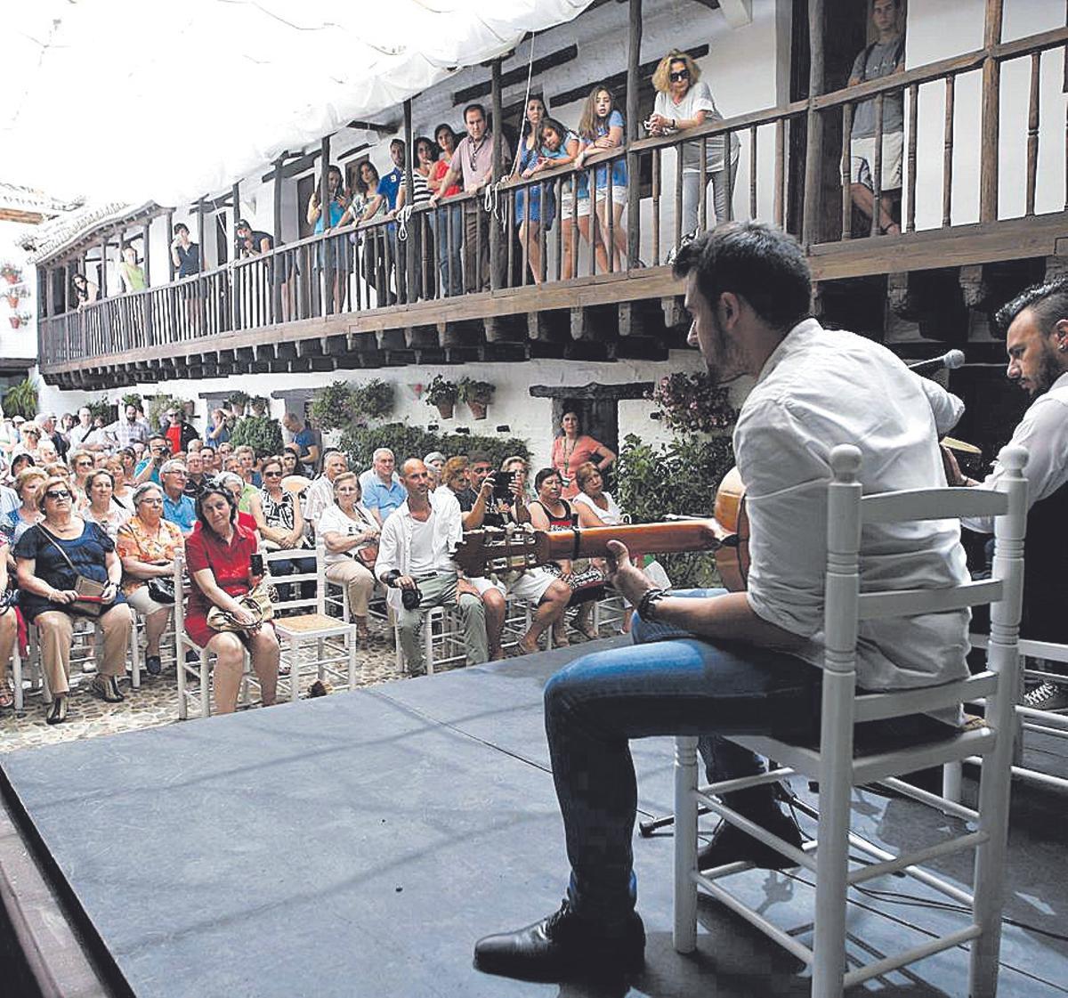 Un patio cordobés atestado de público asiste a una actuación flamenca.