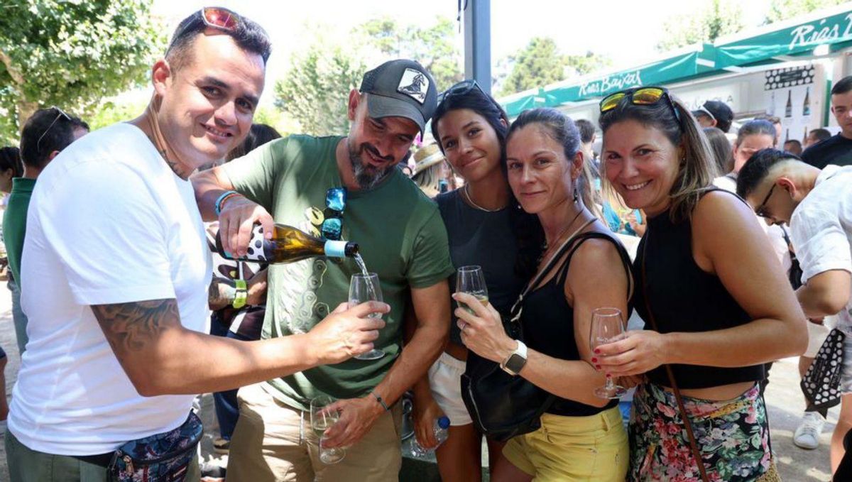 Unos asistentes sirven albariño en los catavinos. | Noé Parga