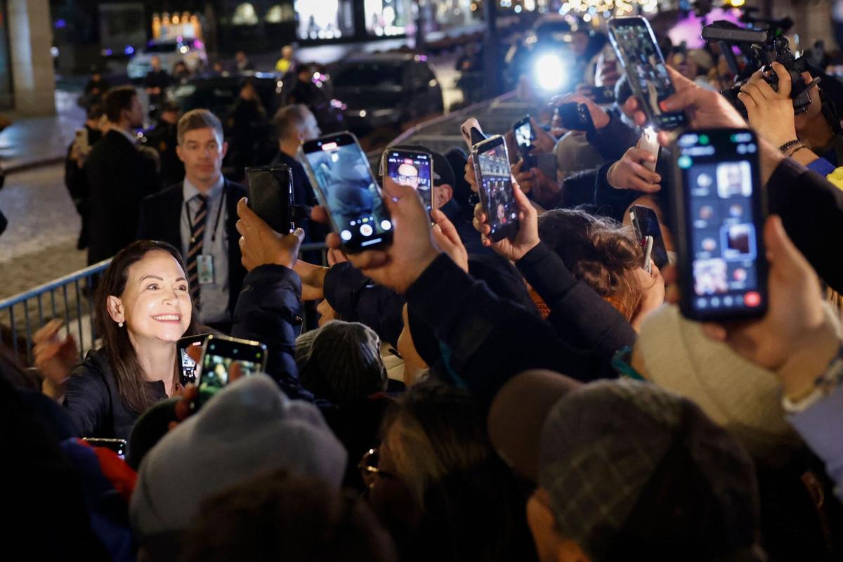 La premio Nobel de la paz, Maria Corina Machado, saluda a los partidarios reunidos fuera del Gran Hotel en Oslo, Noruega, a principios del 11 de diciembre de 2025. Machado llegó a Oslo horas después de que el premio de la líder de la oposición venezolana fuera recogido en su nombre por su hija. (Foto de Odd ANDERSEN / AFP)