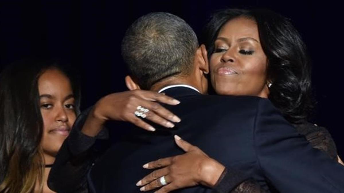 Obama abraza a su mujer, Michelle, en presencia de su hija Malia después de su discurso de despedida en Chicago.
