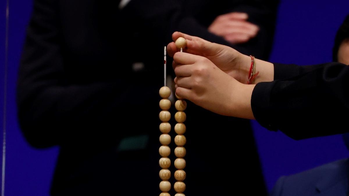 Uno de los niños de San Ildefonso pone una bola en un alambre.