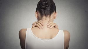 12 DE MAYO DEL 2019. FOTO BAJADA DE 123RF PARA ILUSTRAR UN TEMA SOBRE FIBROMIALGIA. SEÑORA TOCANDOSE LA ESPALDA, QUEJANDOSE DE DOLOR. Healthy lifestyle working conditions. Back and spine disease. Closeup back view tired female massaging her painful neck isolated on gray wall background FOTO DE 123RF