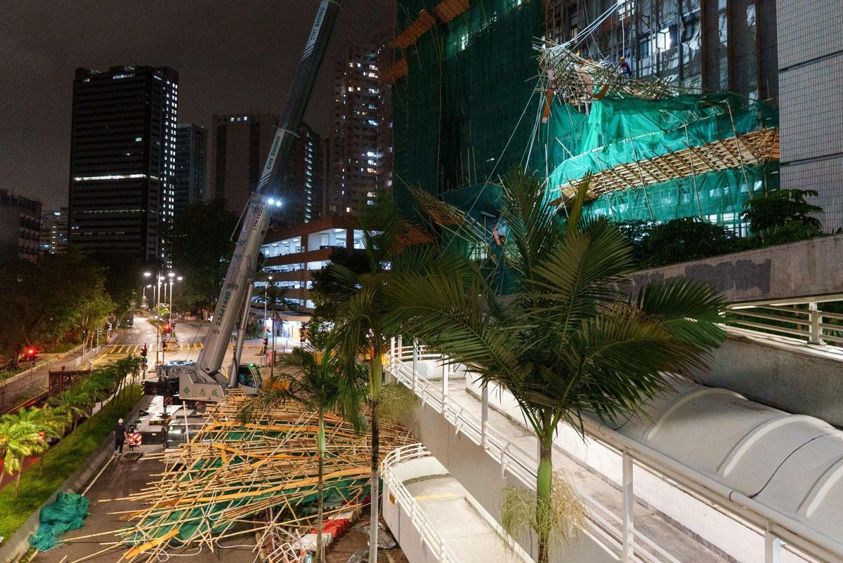 Workers work to remove collapsed scaffolding brought down by strong winds and heavy rain in Hong Kong on July 20, 2025, after Typhoon Wipha skirted along Chinas southern coast. Hong Kong issued its highest tropical cyclone warning July 20 as Typhoon Wipha battered the city, with authorities cancelling classes and grounding hundreds of flights. (Photo by YAN ZHAO / AFP)
