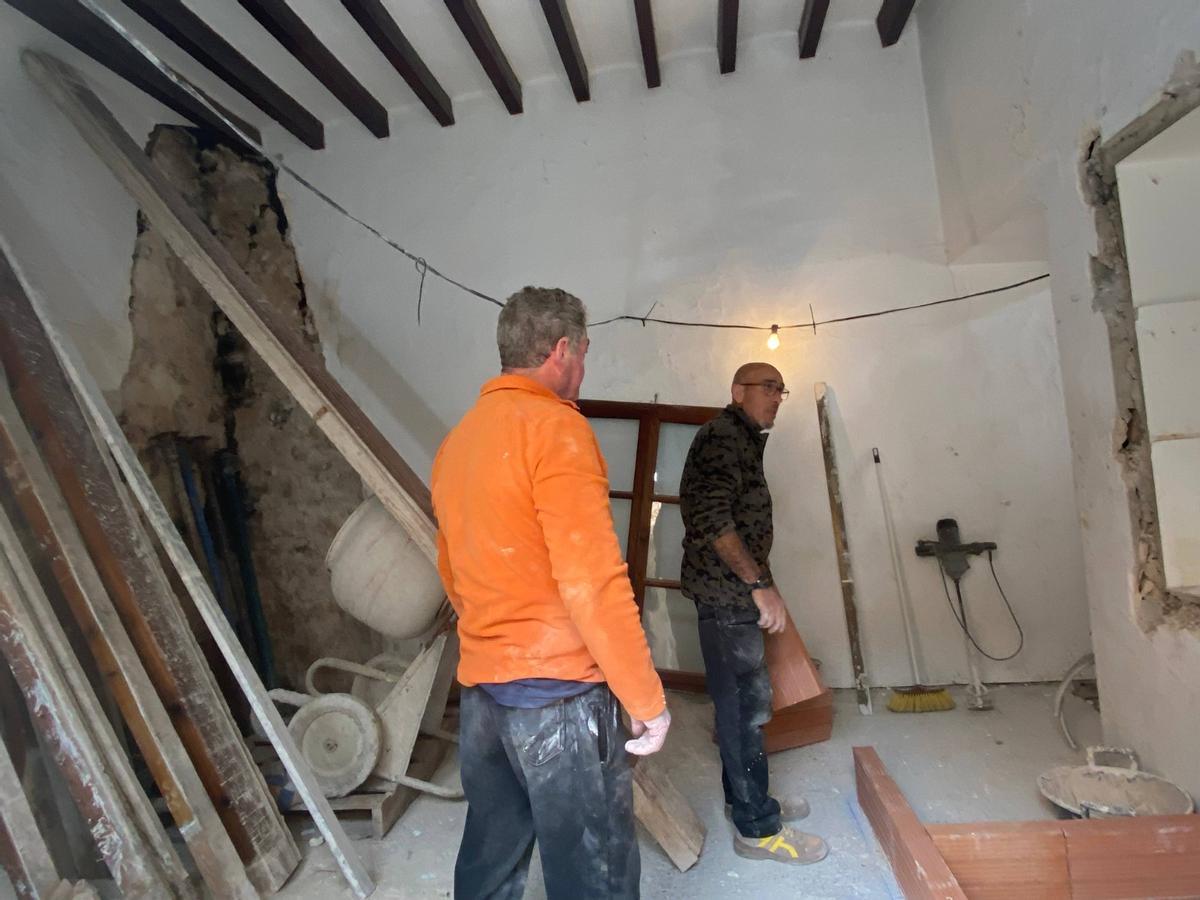 Dos operarios trabajan en el interior de la rectoría.