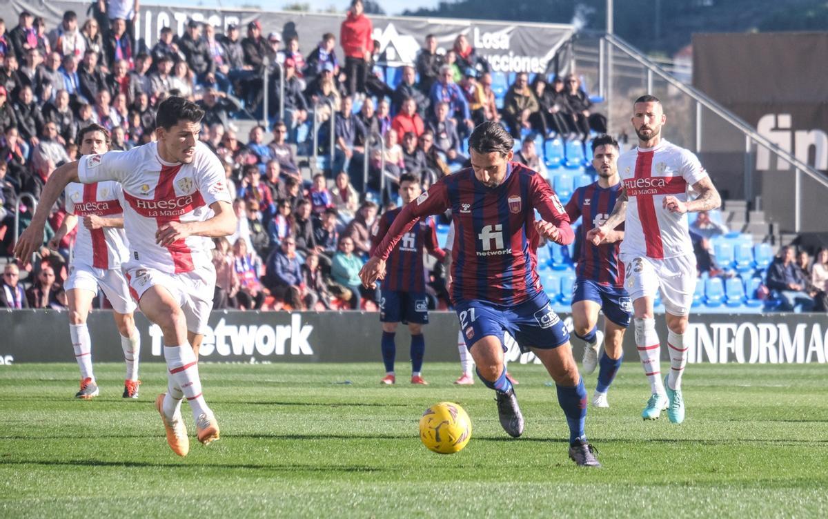 Álex Bernal conduce el balón ante un rival del Huesca