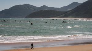 Una mujer paseo por la playa de Trengandín, en Noja.