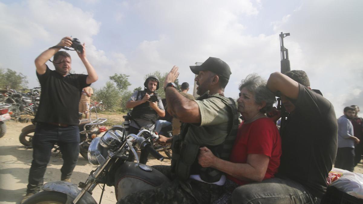 Palestinos transportan a un civil israelí capturado (en el centro), desde Kfar Azza, en el sur de Israel, hacia la Franja de Gaza.