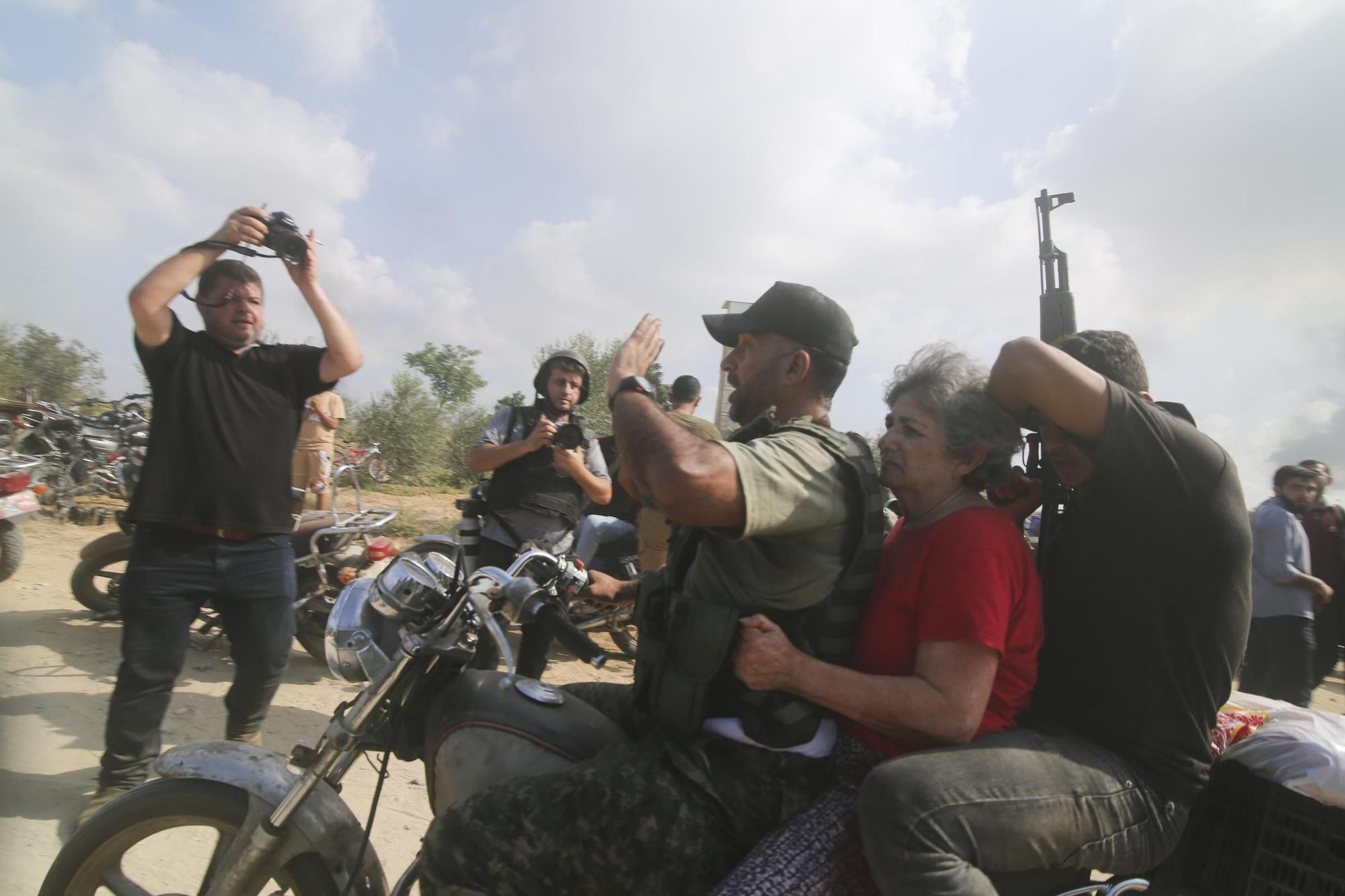 Palestinos transportan a un civil israelí capturado (en el centro), desde Kfar Azza, en el sur de Israel, hacia la Franja de Gaza.