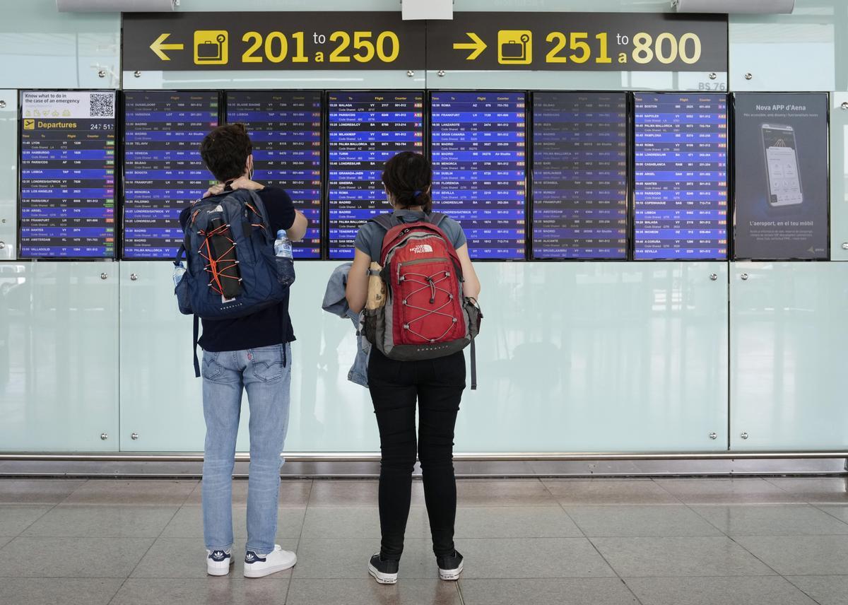 Two travelers checks a info board at Barcelona-El Prat international airport, Barcelona, northeastern Spain, during the first day of Vueling airline’s fight attendants strike, 01 November 2022. Vueling reported that no incidents are happened so far for the strike. EFE/Enric Fontcuberta