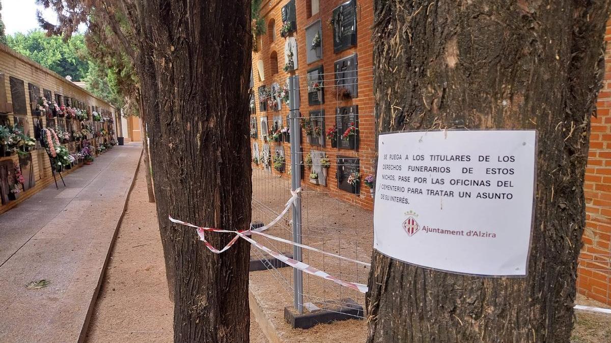 Un cartel advierte sobre el proceso de reconstrucción en el grupo Sant Bernat del cementerio de Alzira, acordonado desde 2023.