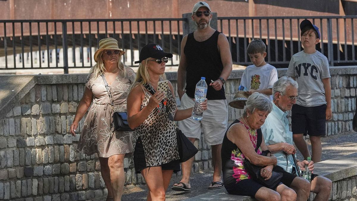 Turistes es resguarden del sol a l'ombra al Barri Vell