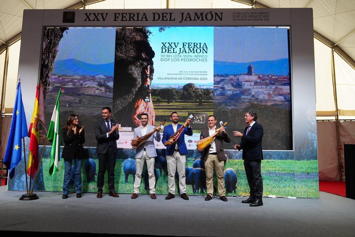 Representantes de las tres empresas premiadas muestran los jamones presentados al concurso de la feria del Jamón.