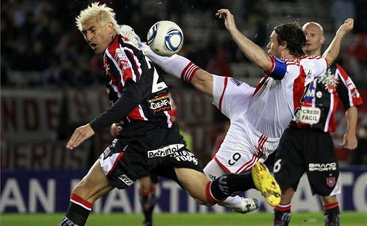 Els jugadors Fernando Cavenaghi (River Plate) i Javier Paez (Chacharita Junior) lluiten per la pilota durant el partit dels dos equips rivals a Buenos Aires, Argentina.
