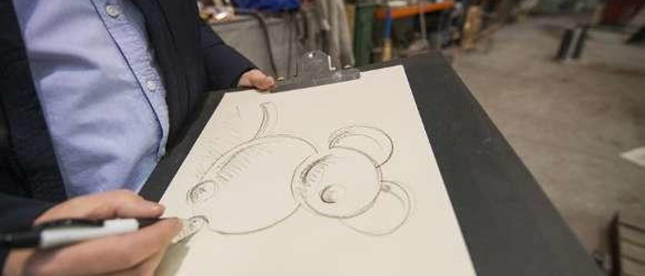 Favila dibuja un boceto del ratón que la fundición Auriga realizará en bronce y pintará de color rojo.