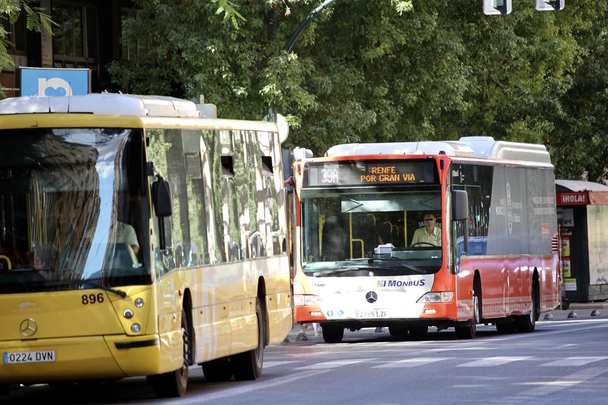 Un autobús interurbano y un urbano circulan por las calles de Murcia.