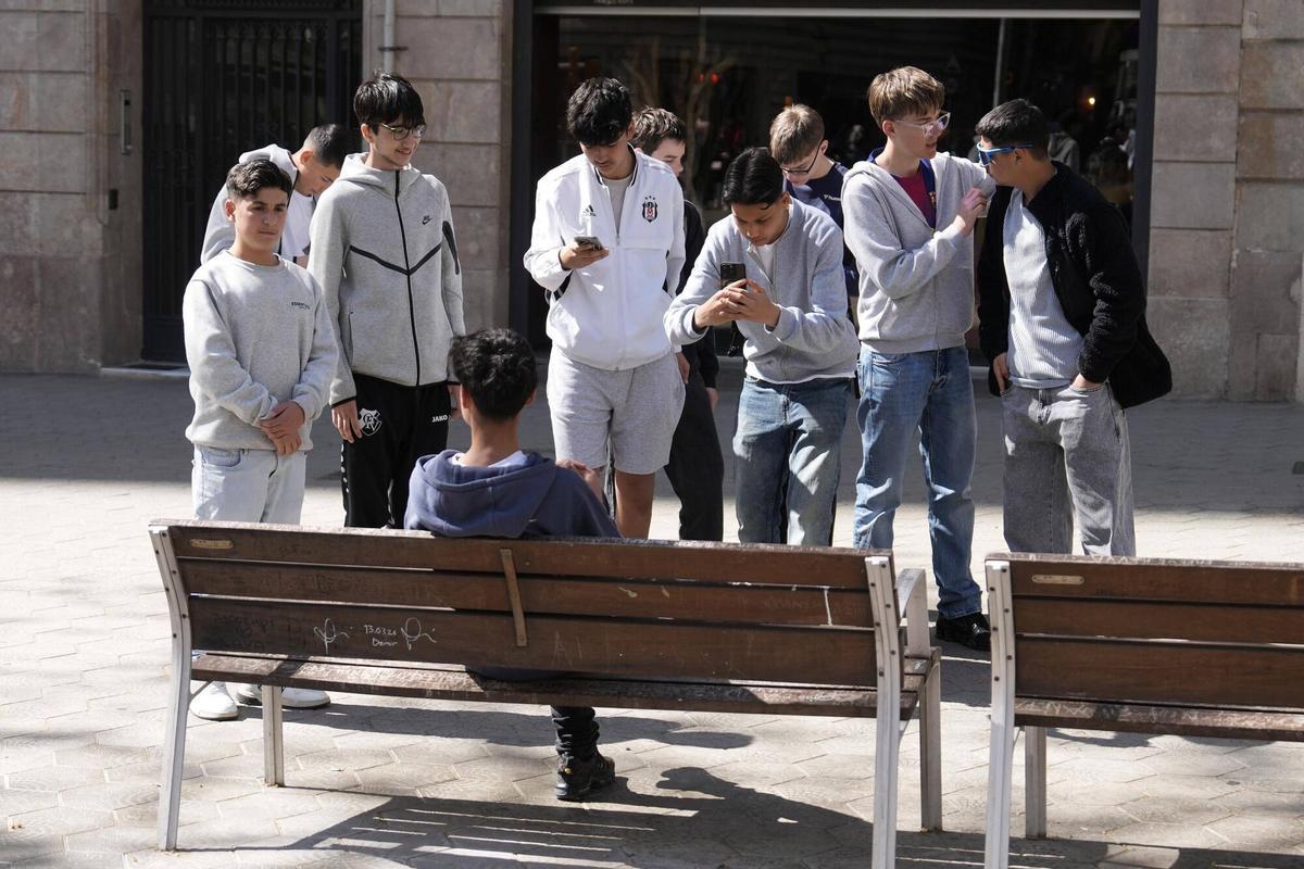 Barcelona 01/04/2026 El banco de Arda Turan. Hay dos bancos situados frente al número 119 del paseo de Gràcia. En uno de ellos (el de la izquierda, mirando al número 119) se hizo una foto el futbolista Arda Turan en 2017 y se convirtió en sitio de peregrinaje de los turistas turcos. Lo quitaron para reformar la plaza y pisieron nuevos y se han vuelto a llenar de firmas. En la foto, unos jóvenes turcos residentes en Alemania se hacen fotos en el banco Fotografía de Ferran Nadeu
