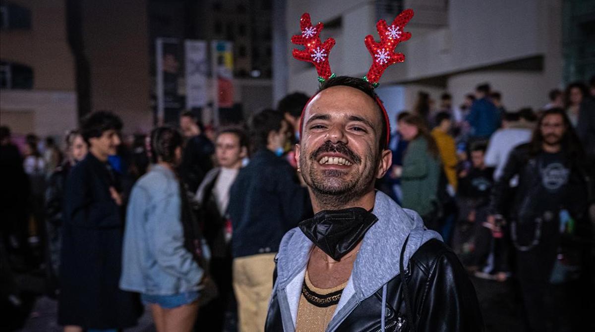 Uno hombre vestido como si celebrara la Navidad celebra en realidad en Barcelona el fin del estado de alarma.