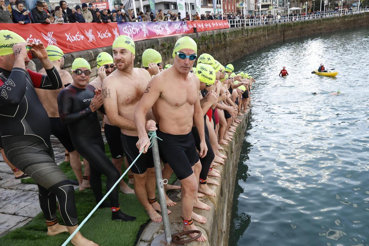 La travesía a nado de Navidad en Gijón congrega un año más a decenas de participantes (en imágenes)