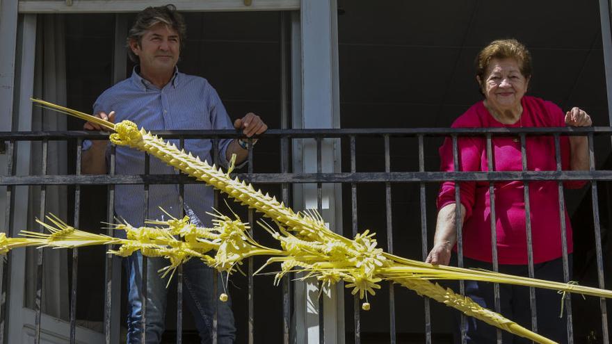 Un hombre y una mujer colocando ayer palma en una fachada, antes de que se cancelase la campaña.