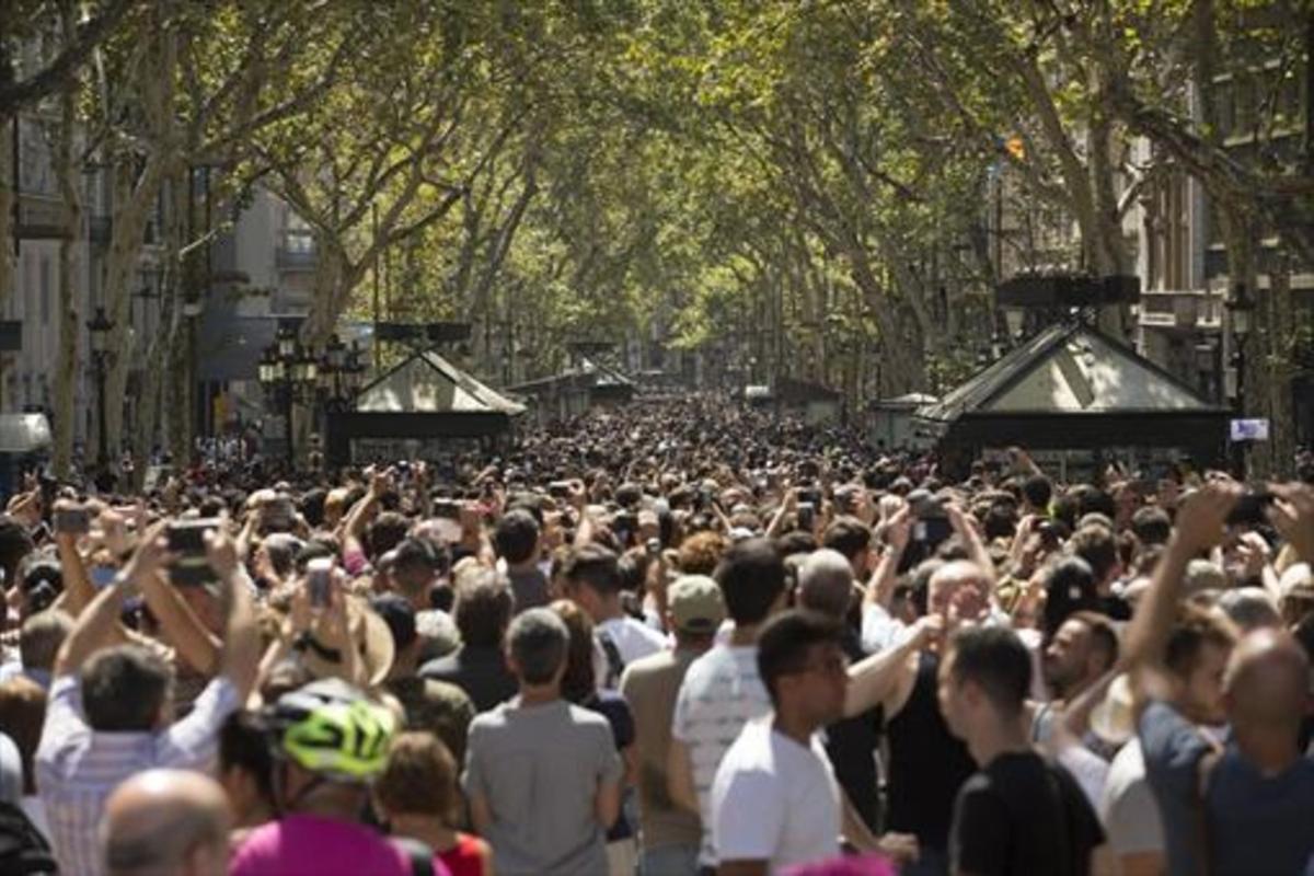 Miles de personas acudieron ayer a la Rambla, al día siguiente de la matanza.