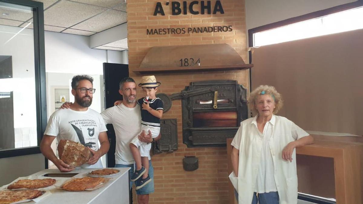 De izq. a dcha: Fernando García Lorenzo, Guillermo Moreira Lorenzo y Digna Catalina Lorenzo, en el nuevo despacho y con el antiguo horno de leña. En brazos de Guillermo su hijo Mahè, representante de una posible séptima generación.