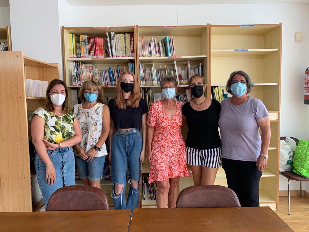 Abbie, que ha digitalizado la biblioteca del colegio la Penya Blanca de Benidoleig, junto a responsables del centro y del ayuntamiento