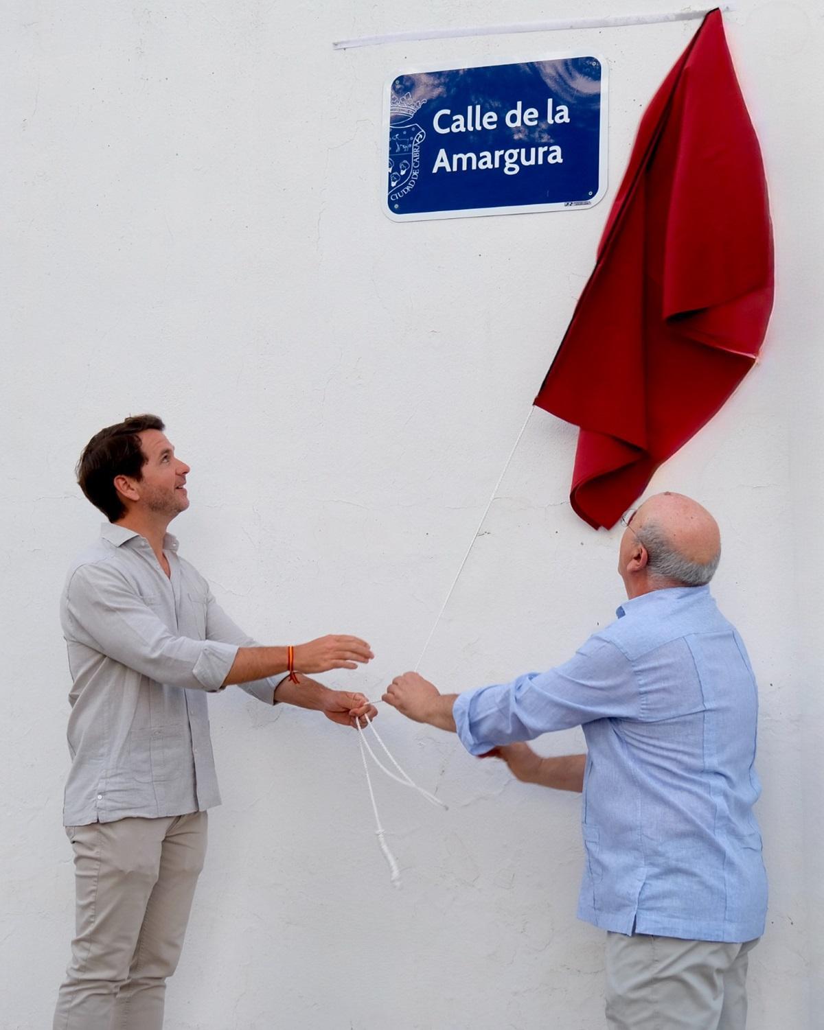 El alcalde de Cabra, Fernando Priego, a la izquierda, descubre la placa con el nombre de la calle de la Amargura.