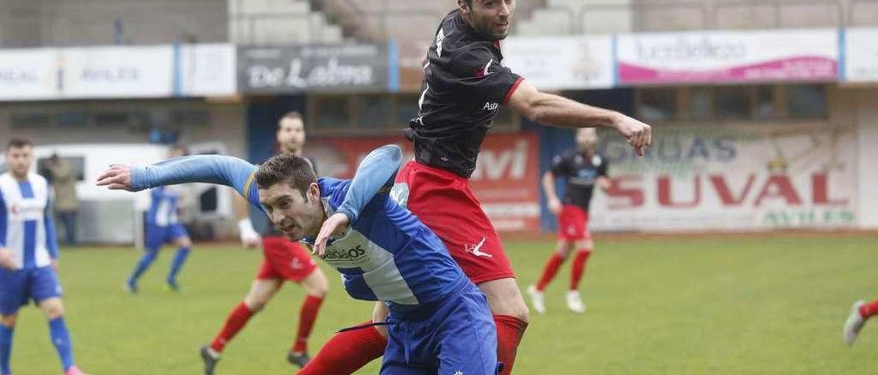 Álvaro Cuello pugna por el balón con un futbolista del Avilés.