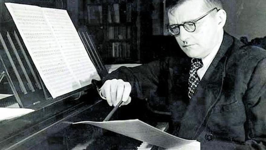 El compositor ruso Dmitri 
Shostakóvich, sentado ante el 
piano, estudia una partitura.
