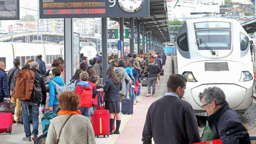 Viajeros esperando uno de los trenes directos de Madrid en la estación de Guixar. // Marta G. Brea