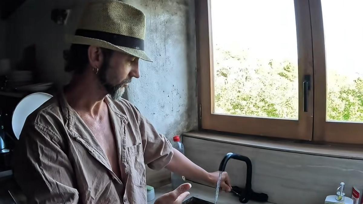 Alain mostrando el grifo de su cocina reformada por él.