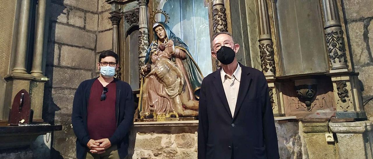 Manuel Rial, voluntario de la parroquia, y el sacerdote José Aldao, junto al retablo en el que se está actuando. |   // CEDIDA