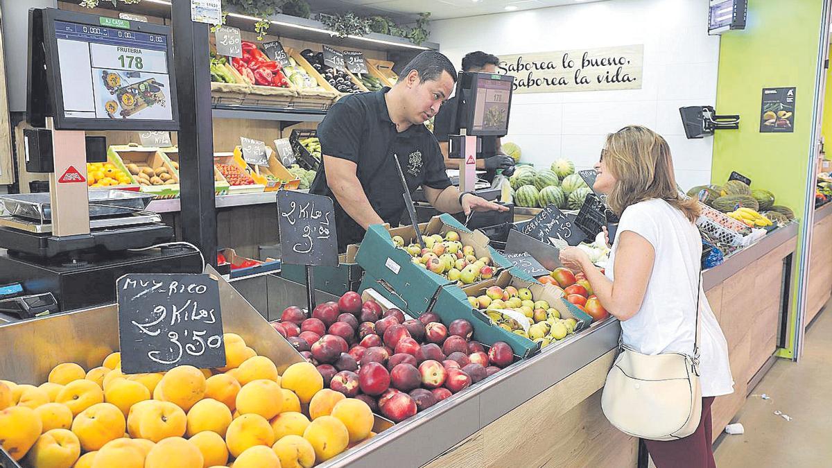 Una mujer pregunta a un frutero por el precio de las peras en el Mercado Central de Zaragoza.