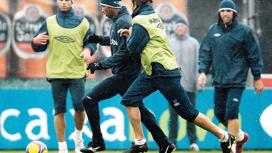 Dinei conduce el balón en el entrenamiento de ayer perseguido por Rosada.