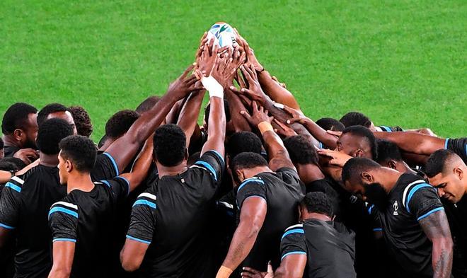 Los jugadores de Fiji rezan antes del partido del Mundial de Rugby en Sapporo, Japón.