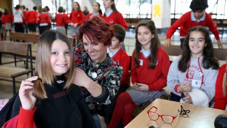 Una peluquera corta el pelo a una de las alumnas del colegio de Valladolid.