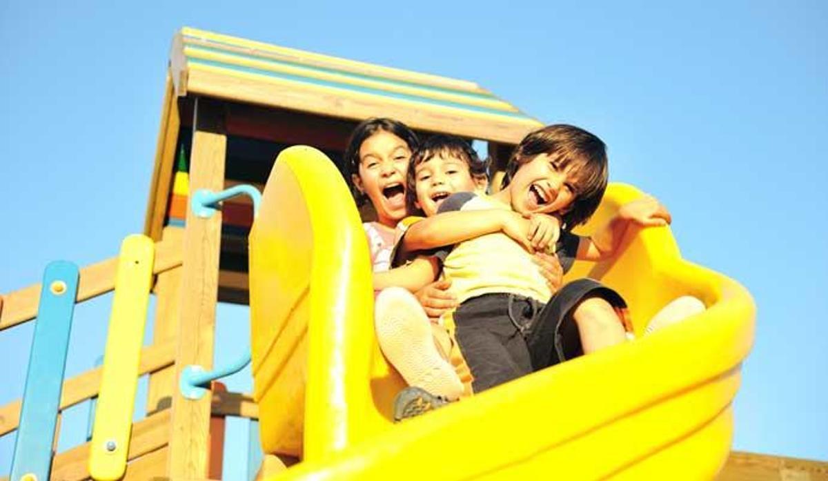 Unos niños disfrutan en un parque de atracciones.