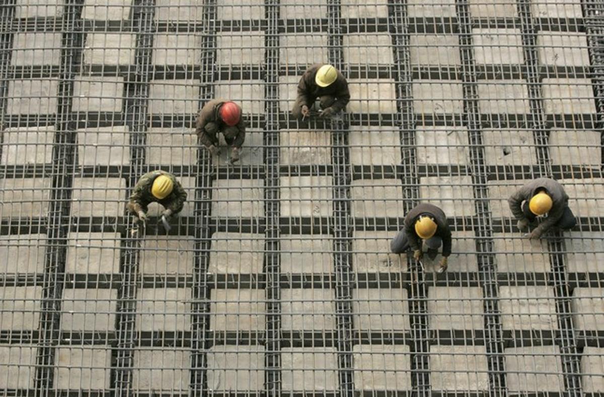 Un grup de treballadors instal·len marcs d’acer en la construcció d’un teatre a Taiyuan, província de Shanxi (Xina).