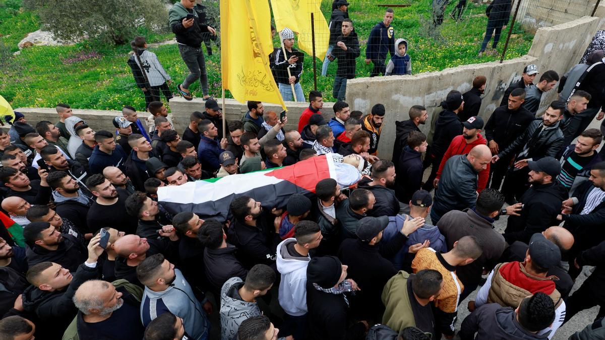 Decenas de palestinos trasladan el cuerpo de un militante abatido en Jenin.