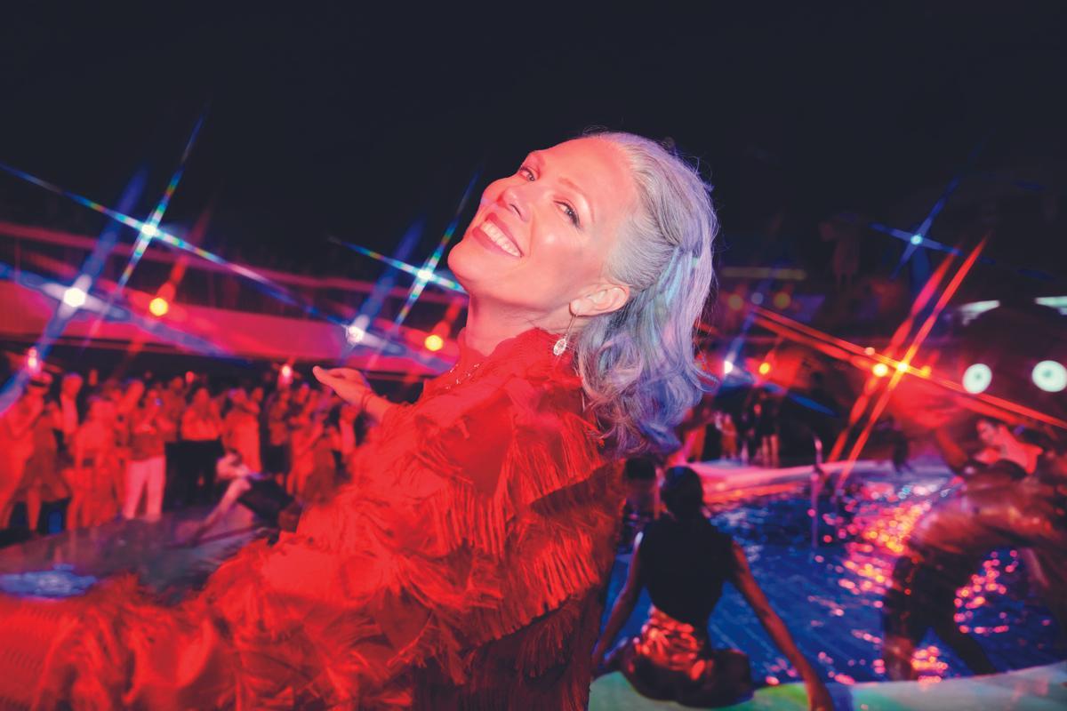 A woman smiles at the camera during Scarlet Night. There's a party behind her and everyone is wearing red. 

Alberto Oviedo, Lifestyle, Now We're Voyaging
Now We're Voyaging Campaign
Photographer: Alberto Oviedo
Studio: Christian Schrader, Kathy Boos
Brand: Billy Bohan