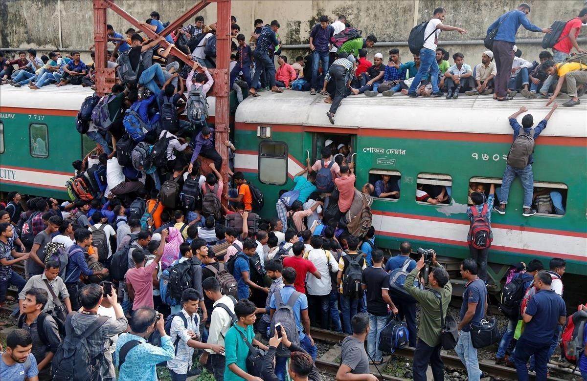 Varias personas viajan este lunes en un tren abarrotado para celebrar la festividad del Eid en Dacca (Bangladesh). La festividad musulmana del Eid al-Fitr marca el final del mes sagrado del Ramadán.